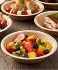 Wooden bowls with various food items on a wooden surface, including fruit salad and desserts.
